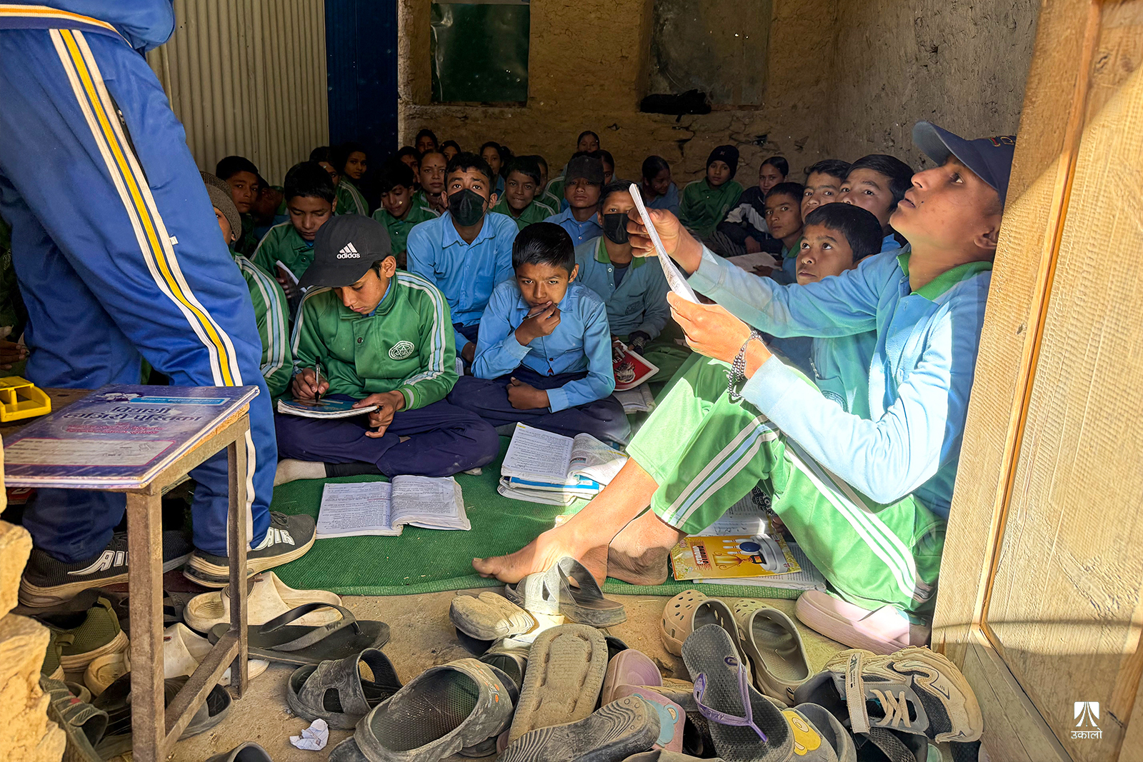 भुइँमा बसेर पढ्न बाध्य कक्षा ८ का विद्यार्थी।